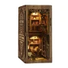 Serre-livres décoratif en bois sculpté représentant une bibliothèque miniature vintage avec éclairage LED chaleureux, inséré entre des livres anciens sur une étagère.