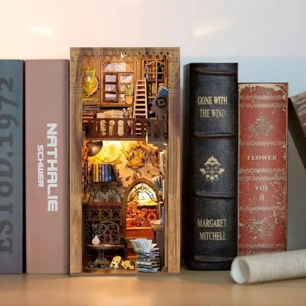 Serre-livres décoratif en bois de style 'book nook' représentant une bibliothèque miniature vintage avec éclairage LED, inséré entre des livres anciens sur une étagère.