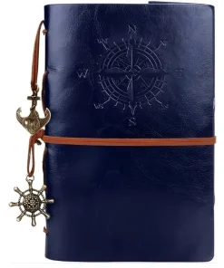 Carnets de voyage cuir bleu vintage, rose des vents et breloques nautiques.
