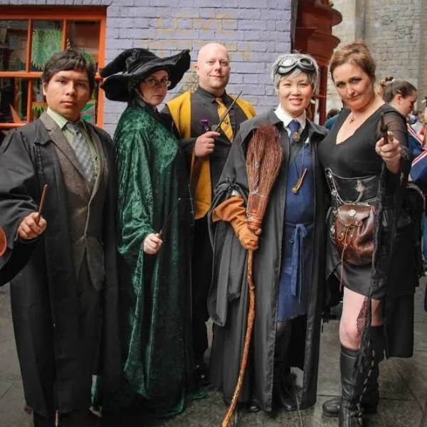 Groupe de fans de Harry Potter en cosplay de sorciers des maisons Gryffondor et Serpentard.