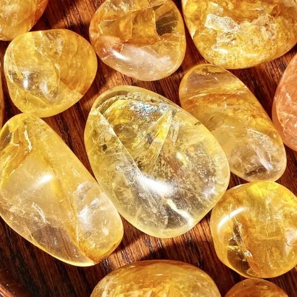 Gros plan sur des pierres de citrine jaune translucides et polies, utilisées en lithothérapie pour l'énergie et la joie.