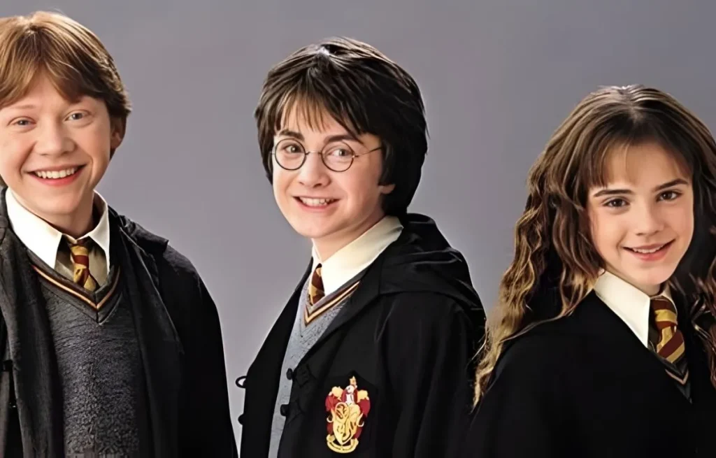 Portrait des trois personnages principaux de Harry Potter — Harry Potter, Ron Weasley et Hermione Granger — portant leurs uniformes de Poudlard avec les cravates rouge et or de la maison Gryffondor.
