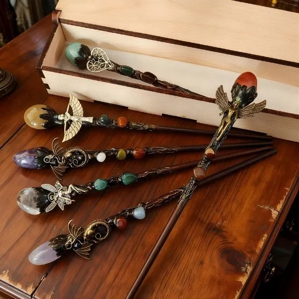 Baguettes magiques artisanales en bois ornées de cristaux naturels et figurines féeriques dans un coffret de présentation