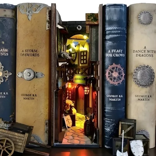 Maquette miniature de ruelle steampunk avec éclairage LED chaud intégrée dans une rangée de livres.