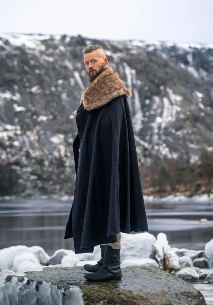 Guerrier viking de profil portant une longue cape noire avec col en fourrure