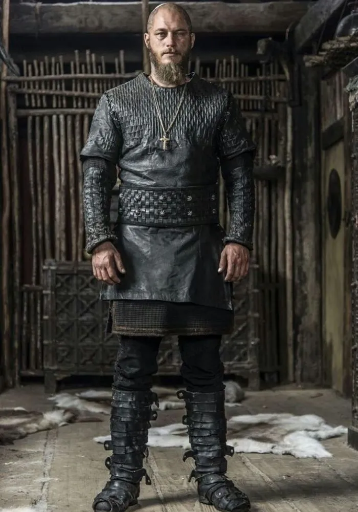 Ragnar Lothbrok en costume complet de guerrier viking avec tunique en cuir noir tressé et pantalon assorti