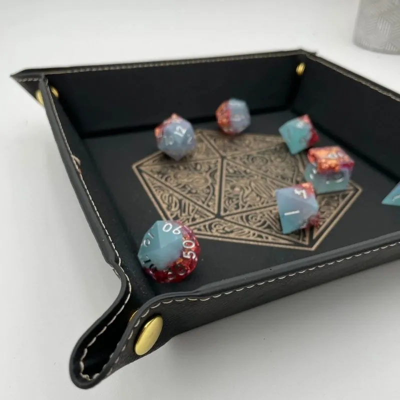 Piste à dés noire carrée avec un set de dés de jeu de rôle bleu et rouge brillant