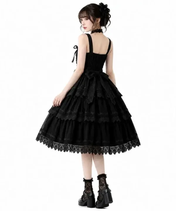 Vetement gothique femme robe JSK noire sans manches avec details dentelle, volants superposes et noeuds frontaux.