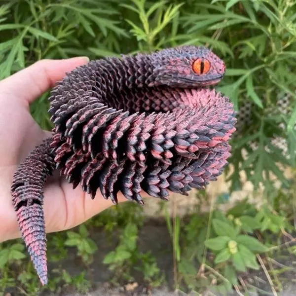 Serpent articulé rouge et noir imprimé 3D, design vipère-dragon aux écailles saillantes.