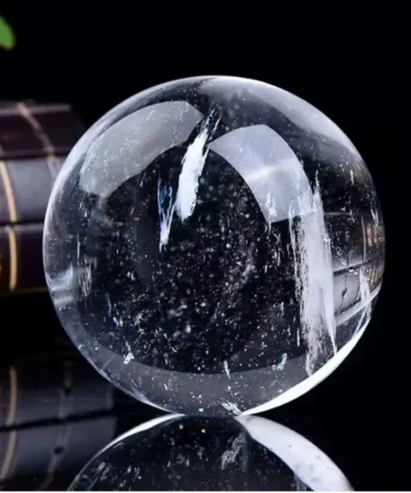 Boule de cristal céleste en quartz blanc naturel poli, inclusions et base.
