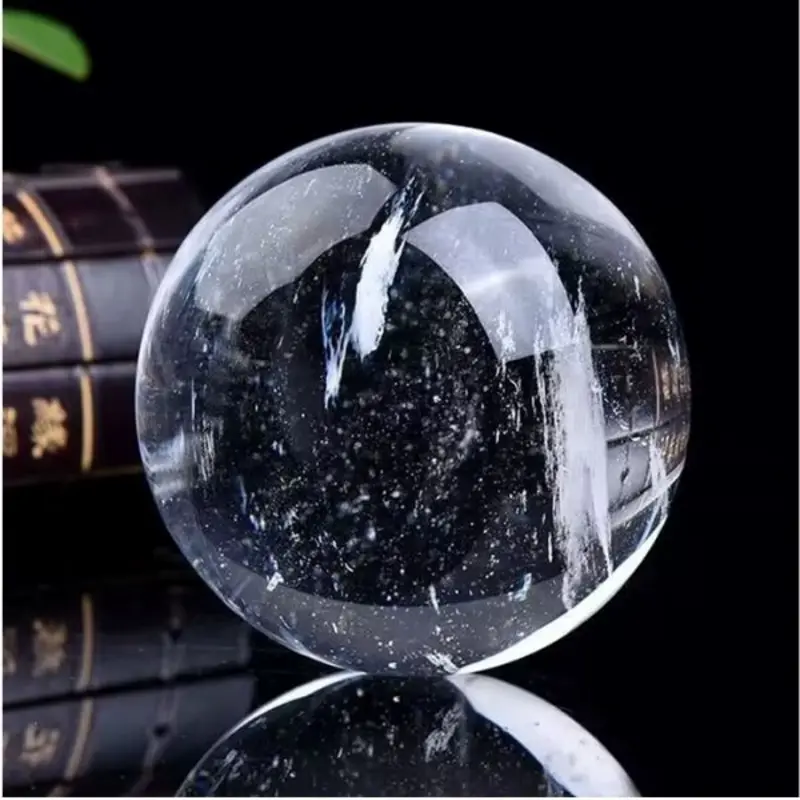 Boule de cristal céleste en quartz blanc naturel poli, inclusions et base.