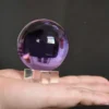 Boule de cristal rose avec finition polie et socle en bois pour univers magique