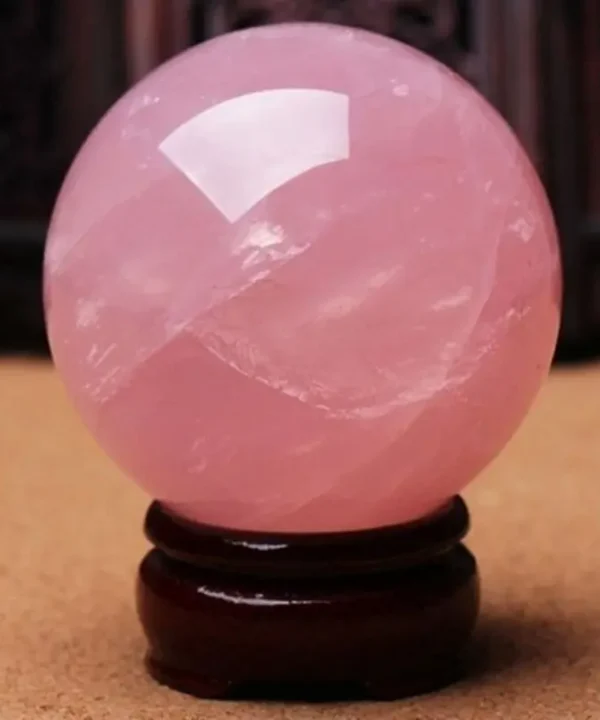 Sphère en quartz rose céleste 40mm sur socle bois sculpté, favorisant paix et amour.
