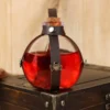 Fiole Potion Magique Sorcière, verre sphérique violet, harnais cuir noir têtes de mort argentées.
